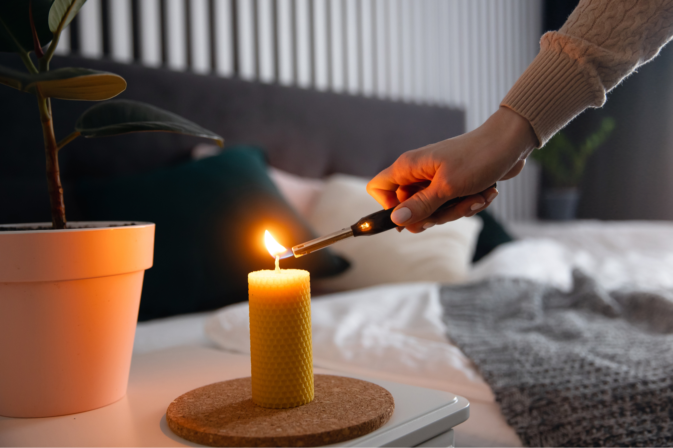 Person lighting a candle on a coffee table